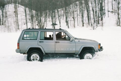 2000 Chevrolet Tahoe - A silver Jeep Cherokee Limited navigates through deep snow.