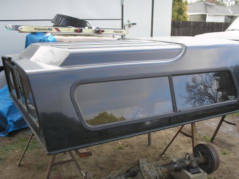 1989 Ford F-350 - A dark-colored truck topper is shown outdoors, supported by stands.