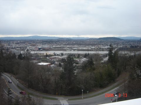 1993 Ford Bronco - A panoramic view of a city and river, with a winding road in the foreground two vehicles and a SuperMotors logo.