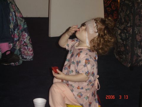 1993 Ford Bronco - A child eats while wearing a face mask and a patterned gown.