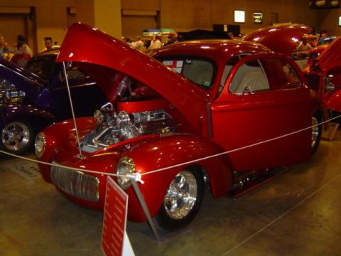 1979 Ford Bronco - Custom hot rod coupe on display with its hood open, revealing a chrome engine.