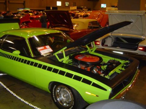 1979 Ford Bronco - A bright green muscle car is displayed indoors with its hood open, revealing the engine compartment.