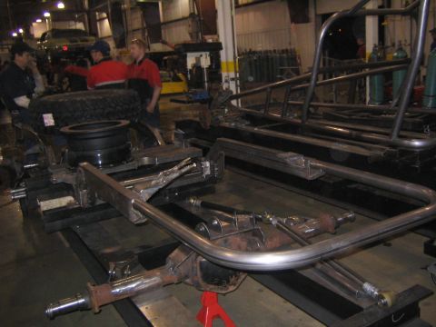 1978 Ford Bronco - A workshop scene shows the construction of a vehicle frame and roll cage, with workers present.