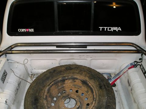 1993 Ford Bronco - Rear view of a white SUV, a spare tire on the tailgate and a sticker on the rear window.