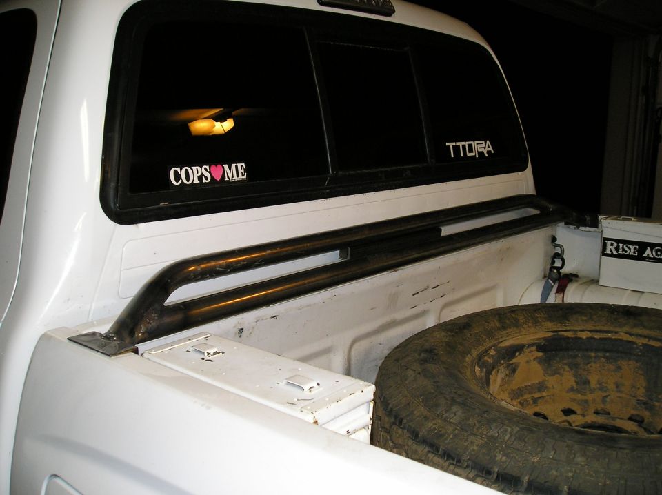 White pickup bed with steel tube bed rail, spare tire and TTORA window decal