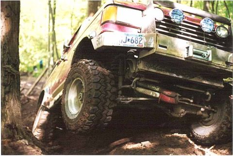 1993 Ford Taurus - Off-road vehicle navigating a wooded trail with its front end angled upwards.
