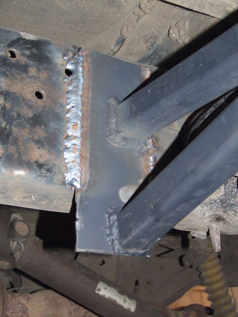 1986 Ford Bronco - Custom rock slider bracket welded to the frame of a vehicle.