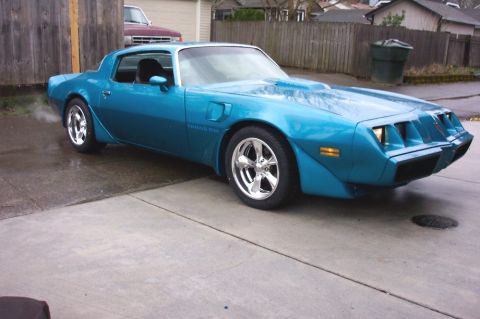 1979 Pontiac Trans Am - A bright blue 1979 Pontiac Trans Am is shown from a three-quarter front view, parked on a concrete driveway.