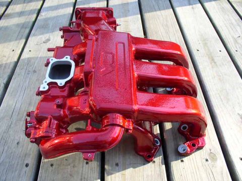1996 Ford Probe - Intake manifold, painted red, shown on a wooden surface.