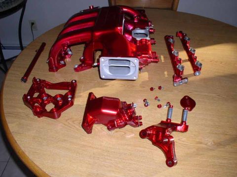 1996 Ford Probe - Disassembled engine intake manifold and parts laid out on a table.