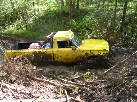 1986 Jeep J-10 - Yellow 1986 Jeep J-10 stuck deep in mud on an off-road trail.