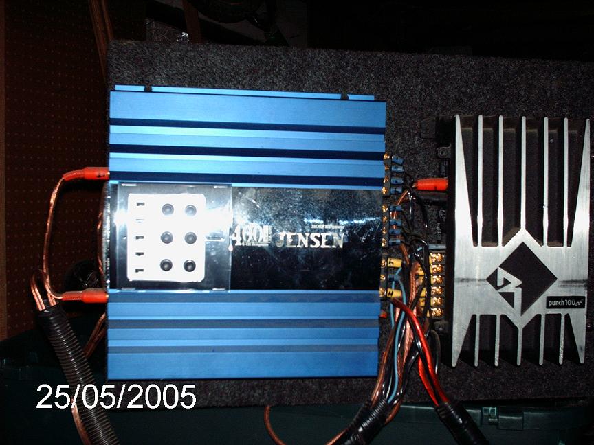 Blue Jensen amplifier and silver Rockford Fosgate Punch amp wired on a carpeted amp rack
