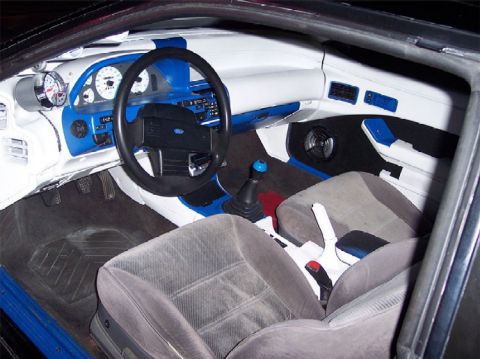 1989 Ford Probe - The interior of a 1989 Ford Probe shows custom blue and white trim with gray seats and a manual shifter.