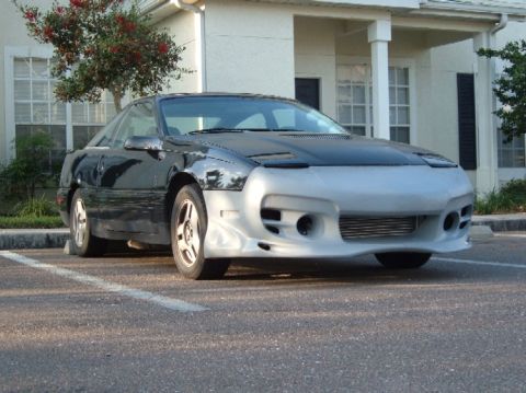 1989 Ford Probe - This sports car features a custom silver front bumper and a black hood, with a visible 'SUPERMOTORS.NET' watermark.