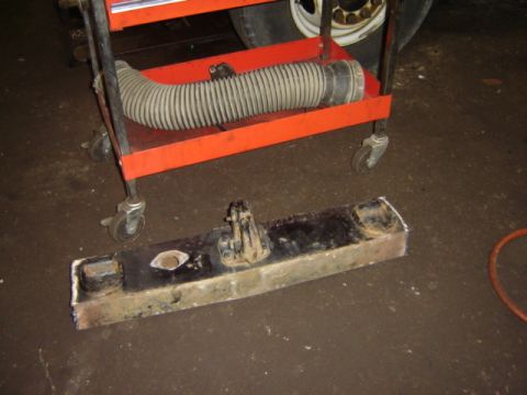 1992 Ford Bronco - A radiator support and air intake hose are shown on a cart in a garage setting.