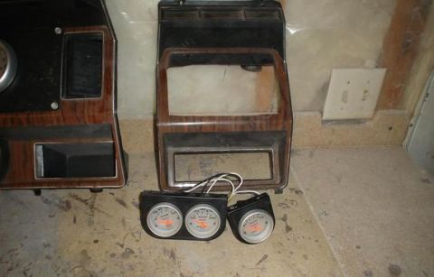 1984 Ford Bronco - Dashboard trim pieces and gauges are laid out on the floor.