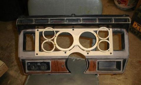1984 Ford Bronco - This dashboard instrument cluster shows openings for gauges and controls, with wood grain accents.