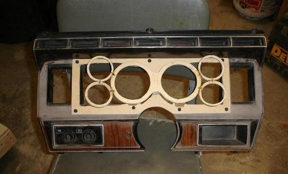Dashboard instrument cluster with wood grain trim and circular gauge openings