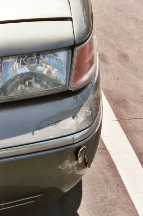 2000 Mercury Grand Marquis - The front corner of a gray 2000 Mercury Grand Marquis shows significant damage to the bumper and fender area.