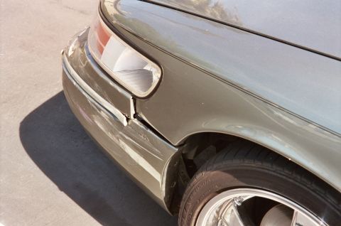 2000 Mercury Grand Marquis - The front passenger side fender of a 2000 Mercury Grand Marquis shows damage and misalignment with the bumper.