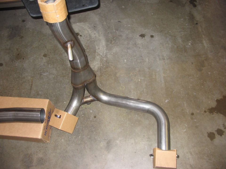 Exhaust Y-pipe with cardboard supports on concrete floor