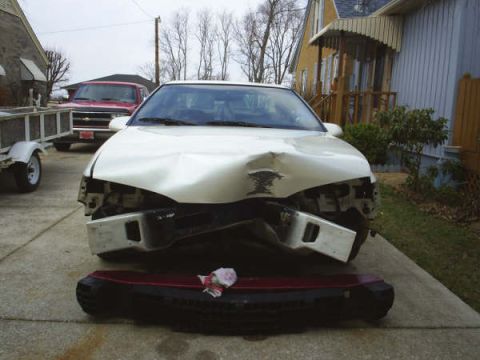 1996 Ford Thunderbird - 1996 Ford Thunderbird shows significant damage to its front end, with the bumper removed.