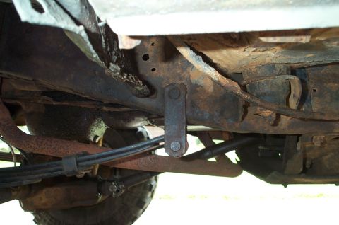 1978 Dodge Power Ram - Close-up view of the rusty undercarriage, focusing on suspension and frame elements.