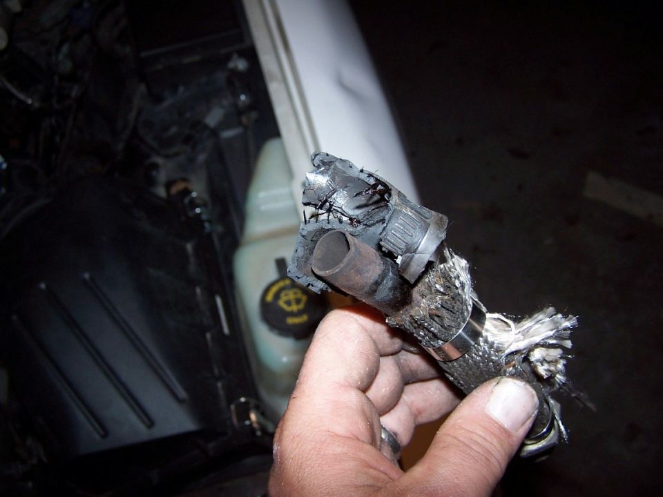 The former heater hose was as hard as a rock.  I had to chip it off the tube. The hose was exposed (through the weldless gap in the metal tube) to exhaust gas direct from the header.

It held for about 5 days.  Hidden by the heat wrap (and initially working) it appeared quite functional.  Didn't think to cut off the heat wrap to see what was underneath.
