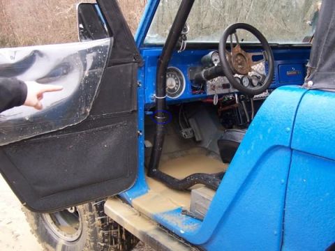 1974 Ford Bronco - The interior of a blue 1974 Ford Bronco shows a roll cage and dashboard with various gauges.