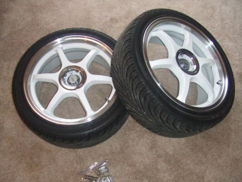 1995 Ford Probe - Two white 5-spoke wheels with tires are displayed on a carpeted floor, with a website logo in the corner.