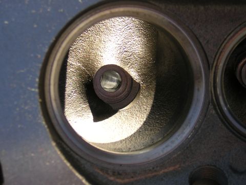 1979 Ford Bronco - This is a close-up view of an engine's cylinder head, showing a valve stem within a combustion chamber.