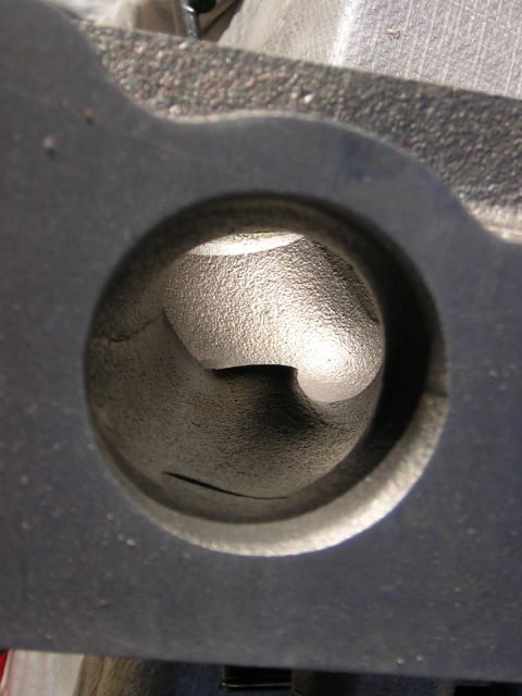 1979 Ford Bronco - This is a close-up view of a cast metal engine cylinder head port, likely for an intake or exhaust valve.