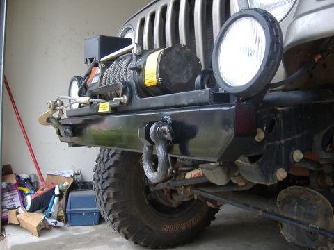 2004 Jeep Wrangler - Front view of a 2004 Jeep Wrangler's heavy-duty bumper, equipped with a winch and auxiliary lighting.