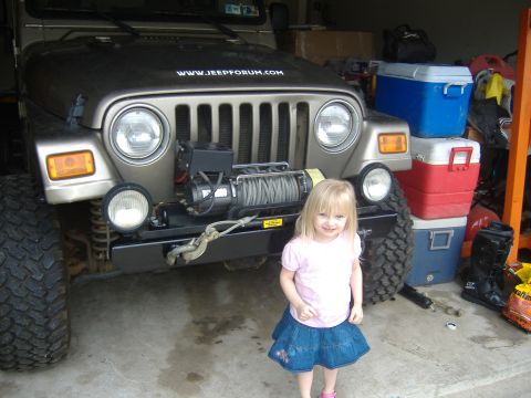 2004 Jeep Wrangler - A 2004 Jeep Wrangler equipped with a winch is shown in a garage setting, with a young girl posing next to the vehicle.