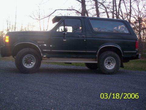1988 Ford Bronco - This 1988 Ford Bronco is shown from the side, its dark green paint and aftermarket wheels.
