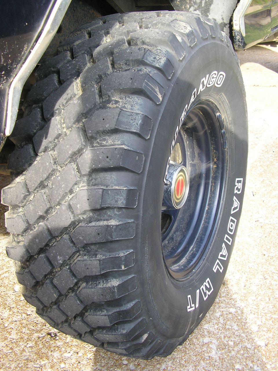 Aggressive mud tire labeled Durango Radial M/T on a black wheel with red center cap