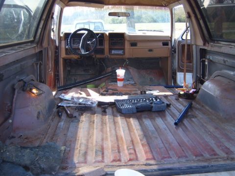 1988 Ford Bronco - Interior view of a 1988 Ford Bronco, showing disassembled parts and tools scattered throughout the cabin.
