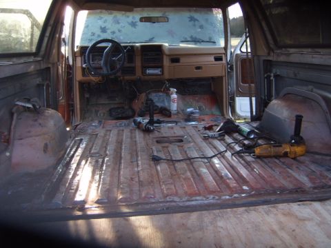 1988 Ford Bronco - Tools and disassembled parts litter the floor of a vintage Ford Bronco's interior.