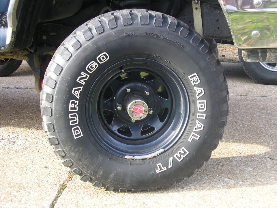 Close-up of a black wheel with a "DURANGO RADIAL M/T" tire. Red center cap visible