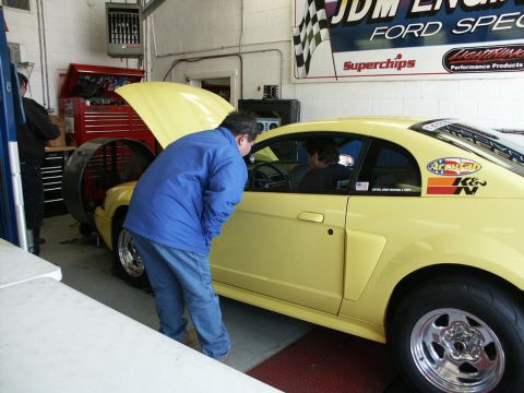 2001 Mercury Grand Marquis - A yellow Ford Mustang is being tested on a dynamometer in a garage setting.