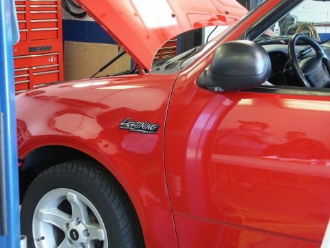 2001 Mercury Grand Marquis - A red pickup truck is shown with its hood open, revealing the interior of the engine bay.