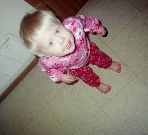 Toddler in pink floral pajamas looking up