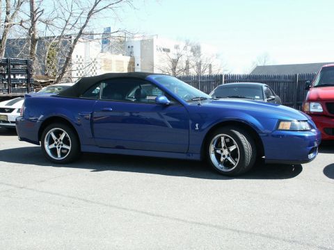 2001 Mercury Grand Marquis - A blue convertible sports car is parked outdoors on a sunny day, with other vehicles visible in the background.
