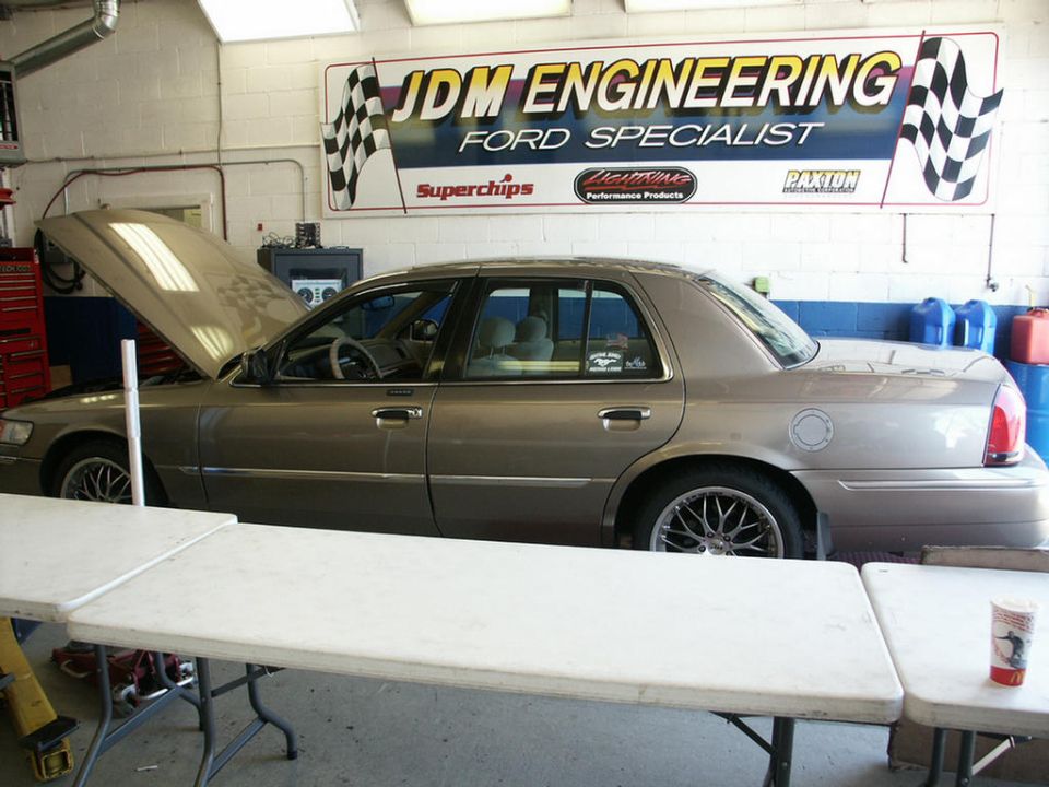 Tan 2001 Mercury Grand Marquis sedan with hood open, parked inside a garage