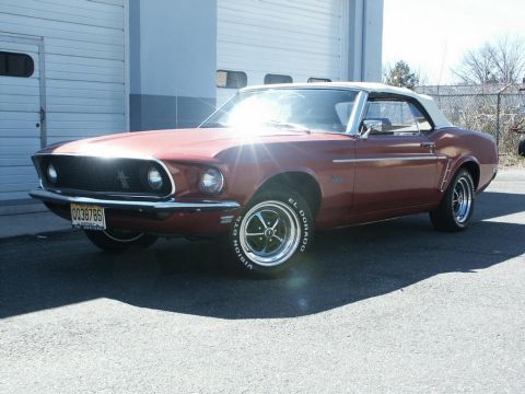 2001 Mercury Grand Marquis - This red 1969 Ford Mustang convertible features a white top and is shown in a front 3/4 view.