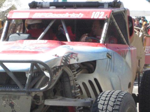 1990 Ford Bronco - shark-mouth-painted front of red BFGoodrich race truck 102 shows two helmeted occupants behind the roll cage.