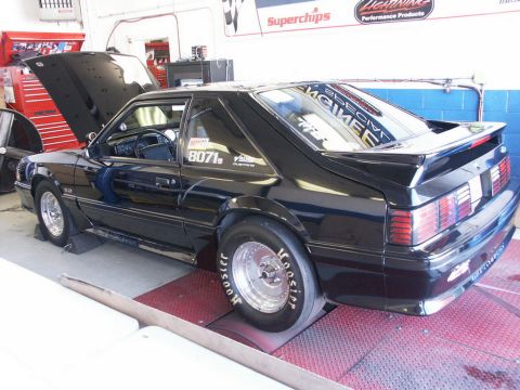 2001 Mercury Grand Marquis - A black coupe with racing slicks is on a dynamometer with its hood open.