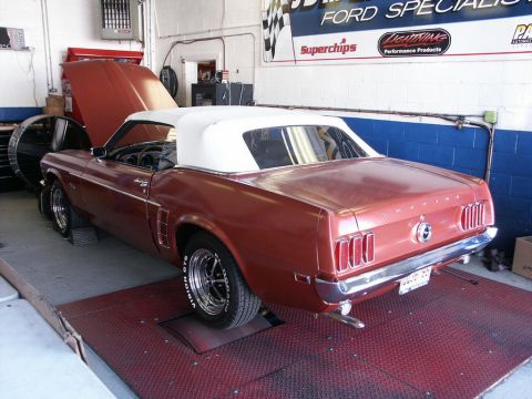 2001 Mercury Grand Marquis - A classic Ford Mustang convertible is positioned on a dynamometer in a garage setting.