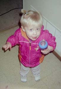 2002 Oldsmobile Aurora - Toddler holding a bottle indoors, with a watermark from SUPERMOTORS.