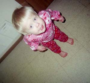 2002 Oldsmobile Aurora - Toddler in pink floral pajamas looking up from a tiled floor.